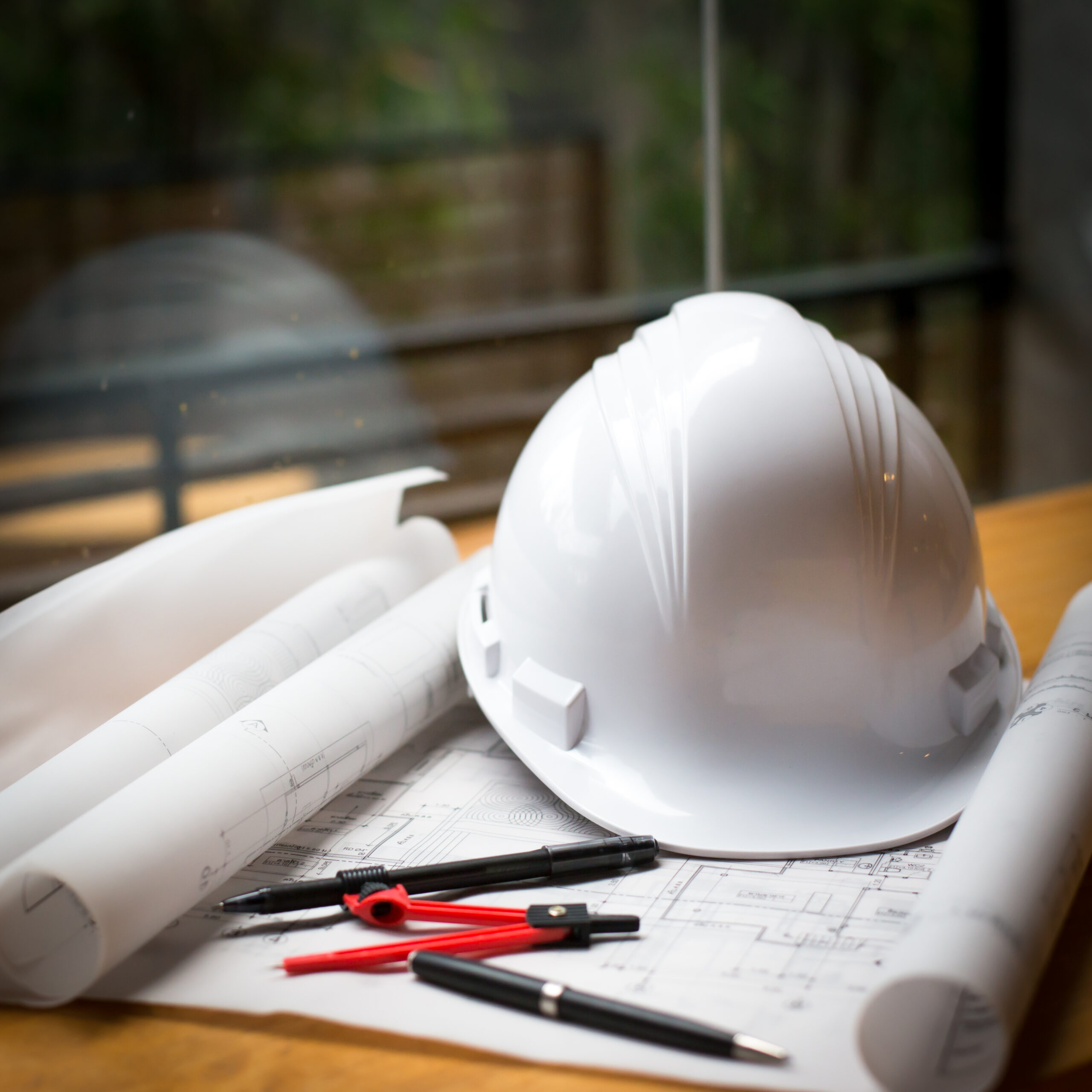 construction concept image helmet rolled blueprints on wooden bo